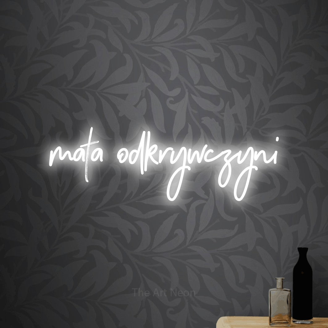 LED neon sign reading “mała odkrywczyni”, arranged in a single line.