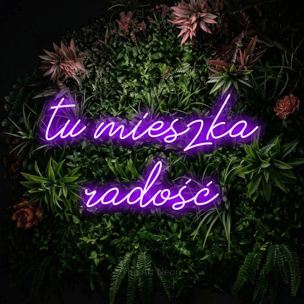LED neon sign reading “tu mieszka radość”, arranged in two lines.