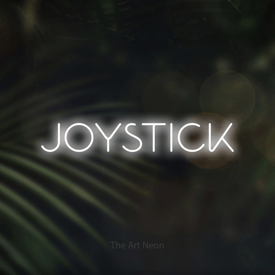 LED neon sign reading “JOYSTICK”, arranged in a single line.