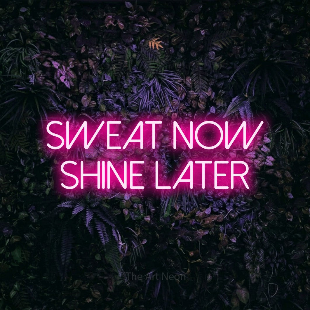 LED neon sign reading “SWEAT now shine later”, arranged in two lines.