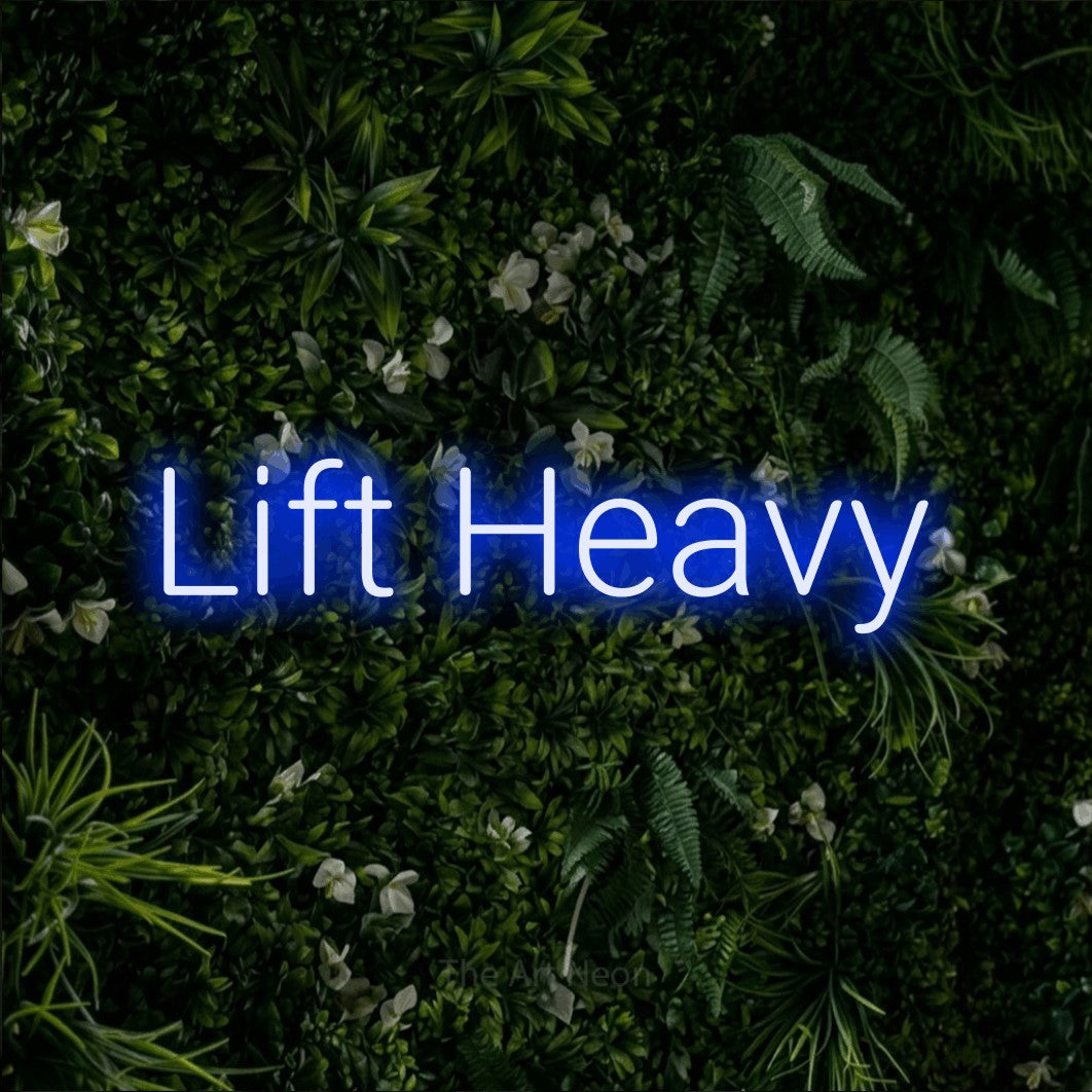 LED neon sign reading “Lift Heavy”, arranged in a single line.