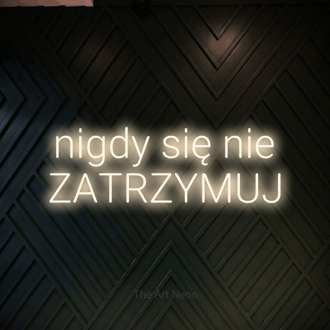 LED neon sign reading “nigdy się nie ZATRZYMUJ”, arranged in two lines.