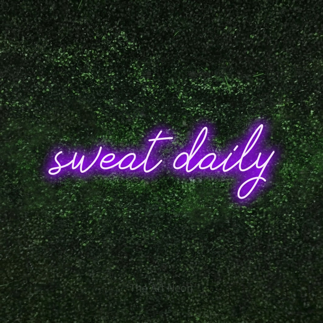 LED neon sign reading “sweat daily”, arranged in a single line.