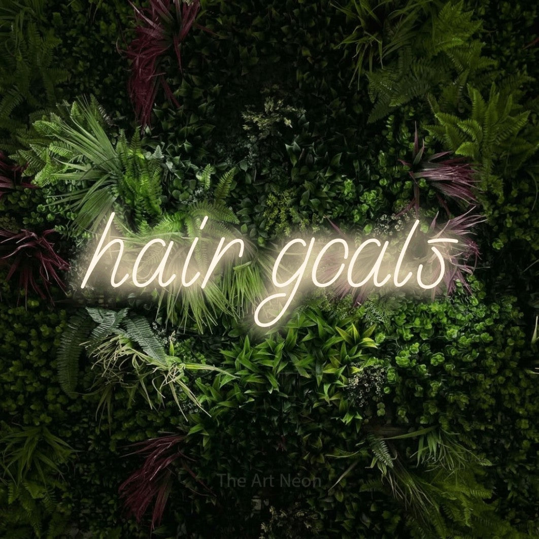 LED neon sign reading “hair goals”, arranged in a single line.