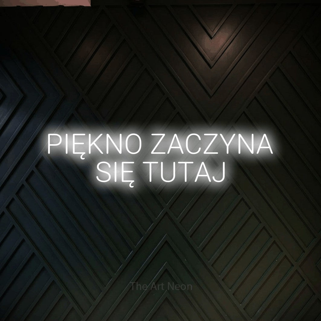 LED neon sign reading “PIĘKNO ZACZYNA SIĘ TUTAJ”, arranged in two lines.
