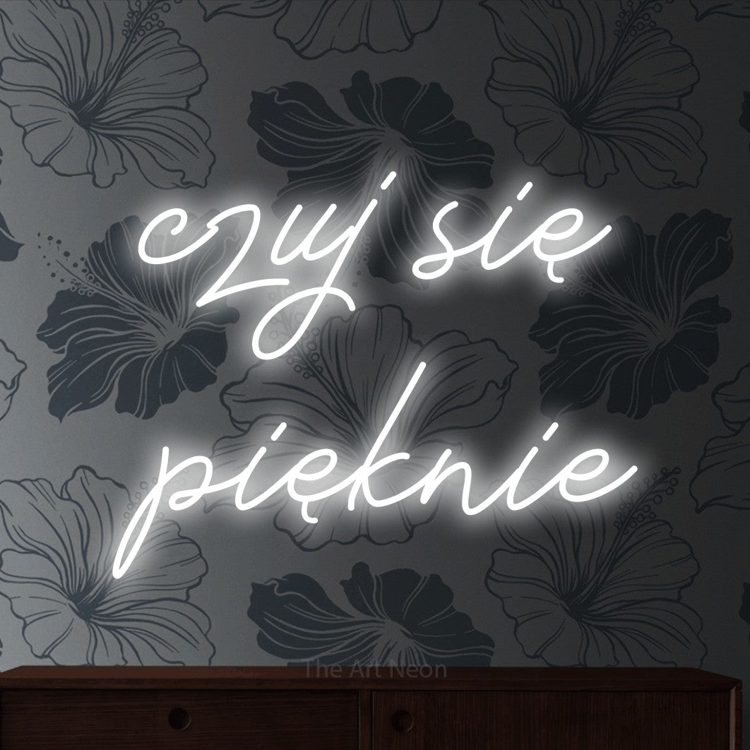 LED neon sign reading “czuj się pięknie”, arranged in two lines.