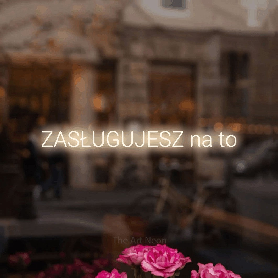LED neon sign reading “ZASŁUGUJESZ na to”, arranged in a single line.