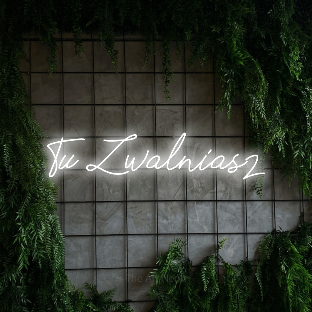 LED neon sign reading “Tu Zwalniasz”, arranged in a single line.