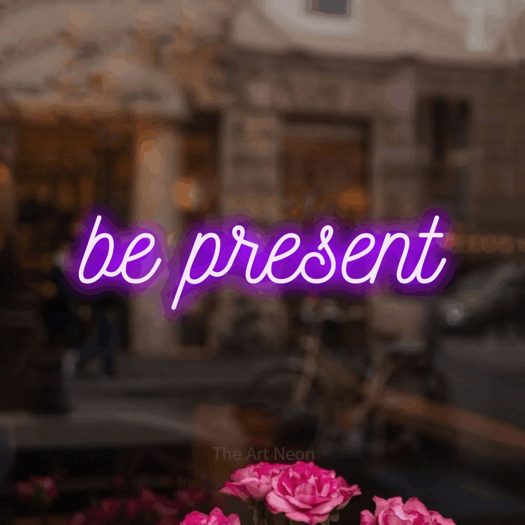 LED neon sign reading “be present”, arranged in a single line.