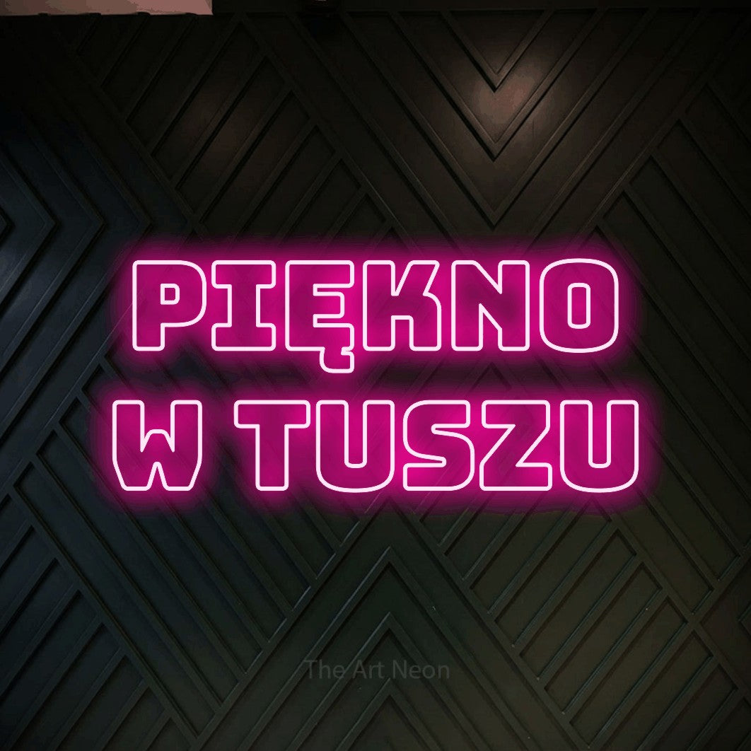 LED neon sign reading “PIĘKNO W TUSZU”, arranged in two lines.