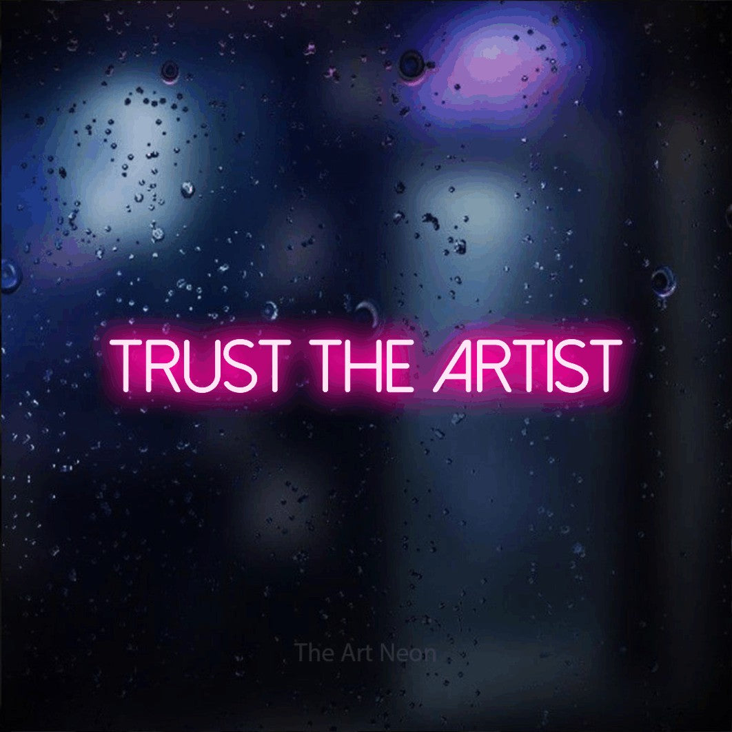 LED neon sign reading “Trust the Artist”, arranged in a single line.