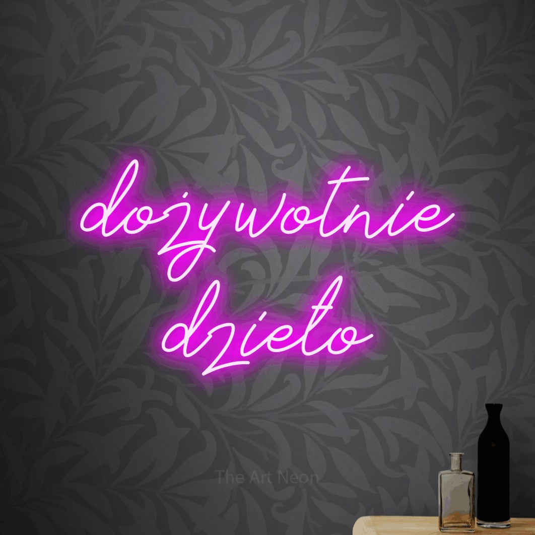 LED neon sign reading “dożywotnie dzieło”, arranged in two lines.