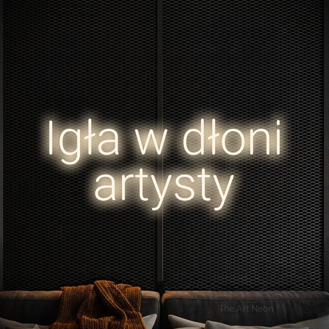 LED neon sign reading “Igła w dłoni artysty”, arranged in two lines.