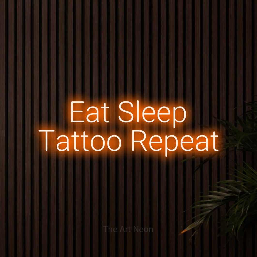 LED neon sign reading “Eat Sleep Tattoo Repeat”, arranged in two lines.