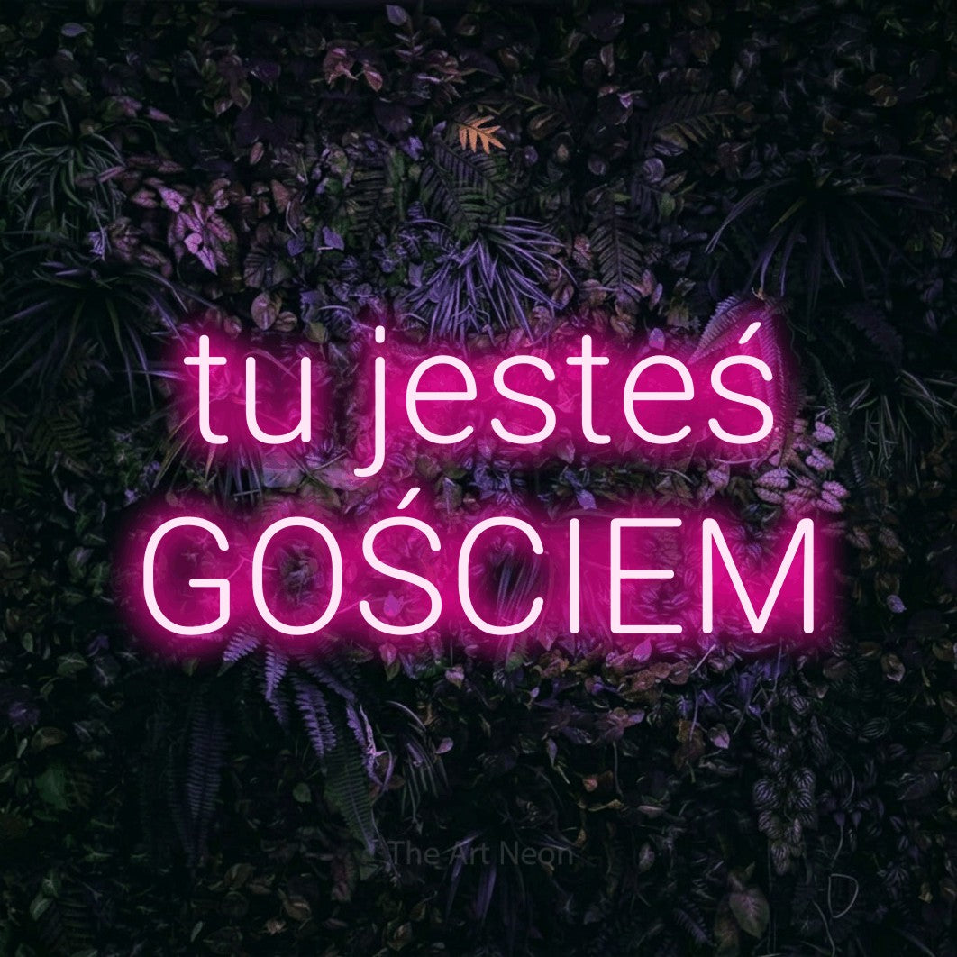LED neon sign reading “tu jesteś GOŚCIEM”, arranged in two lines.