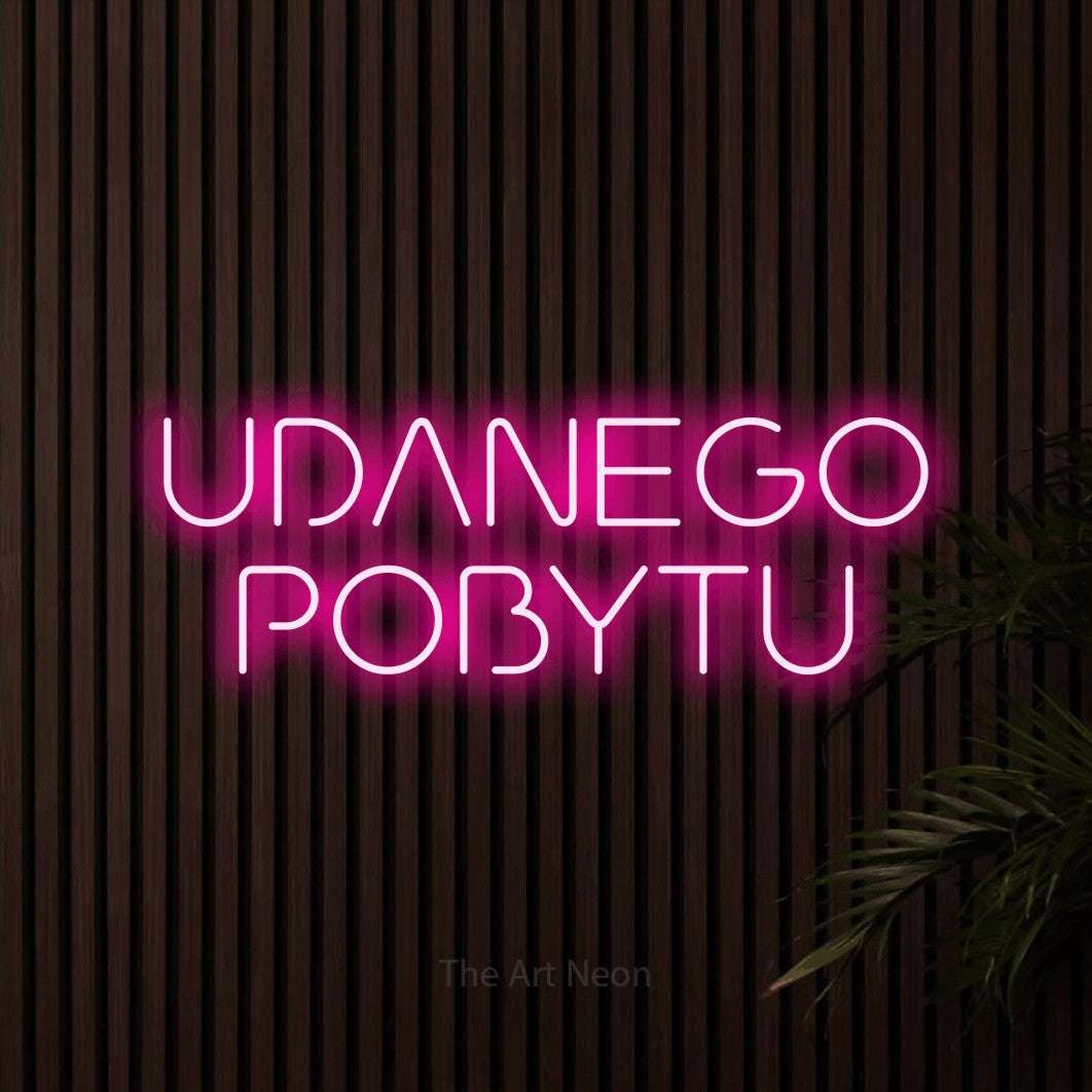 LED neon sign reading “UDANEGO POBYTU”, arranged in two lines.