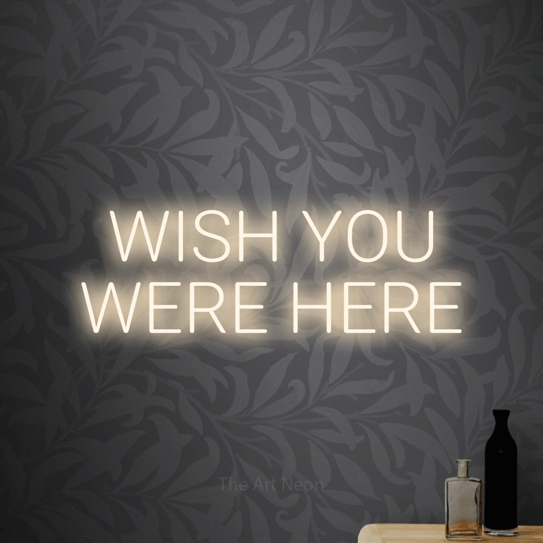 LED neon sign reading “WISH YOU WERE HERE”, arranged in two lines.