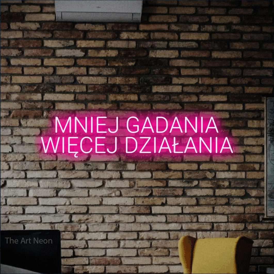 LED neon sign reading “MNIEJ GADANIA WIĘCEJ DZIAŁANIA”, arranged in two lines.