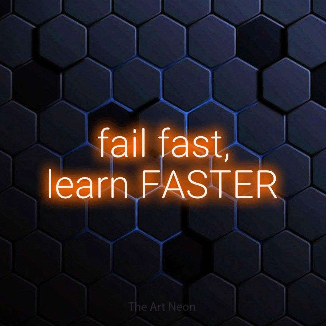 LED neon sign reading “fail fast, learn FASTER”, arranged in two lines.
