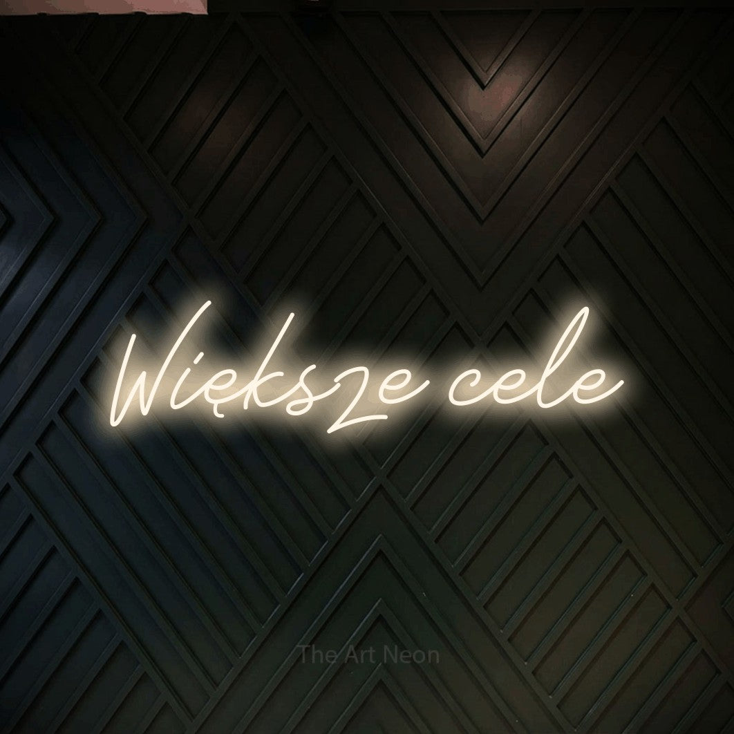 LED neon sign reading “Większe cele”, arranged in a single line.