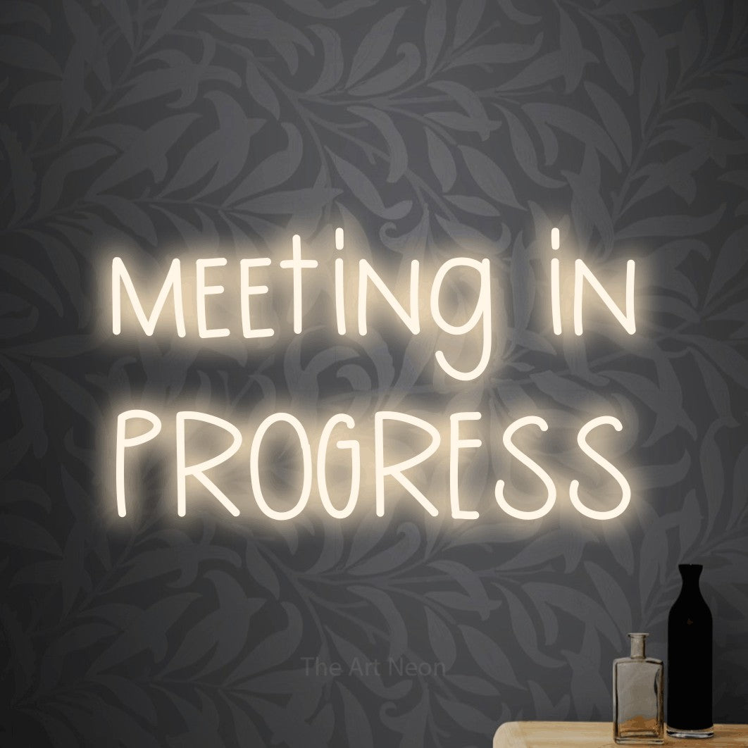 LED neon sign reading “meeting in PROGRESS”, arranged in two lines.