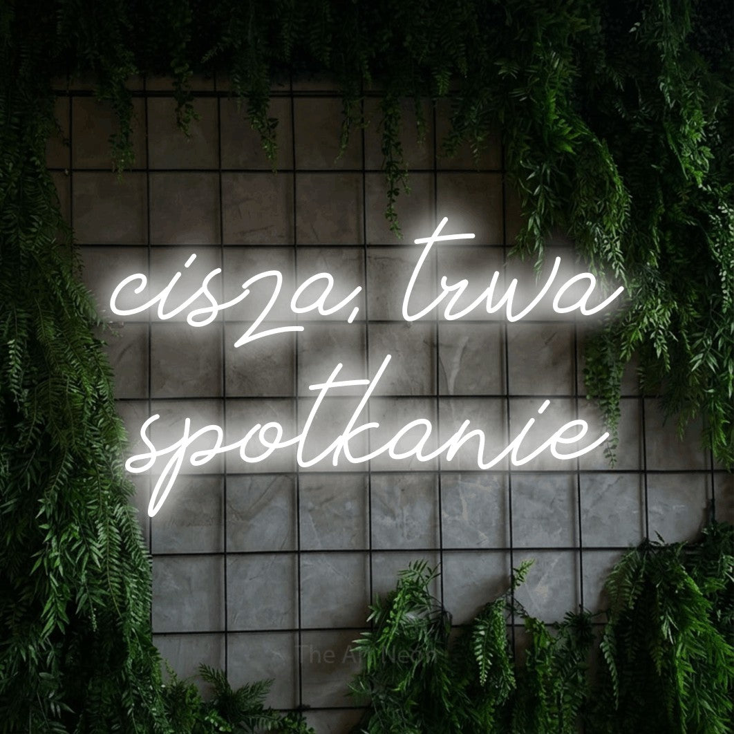 LED neon sign reading “cisza, trwa spotkanie”, arranged in two lines.