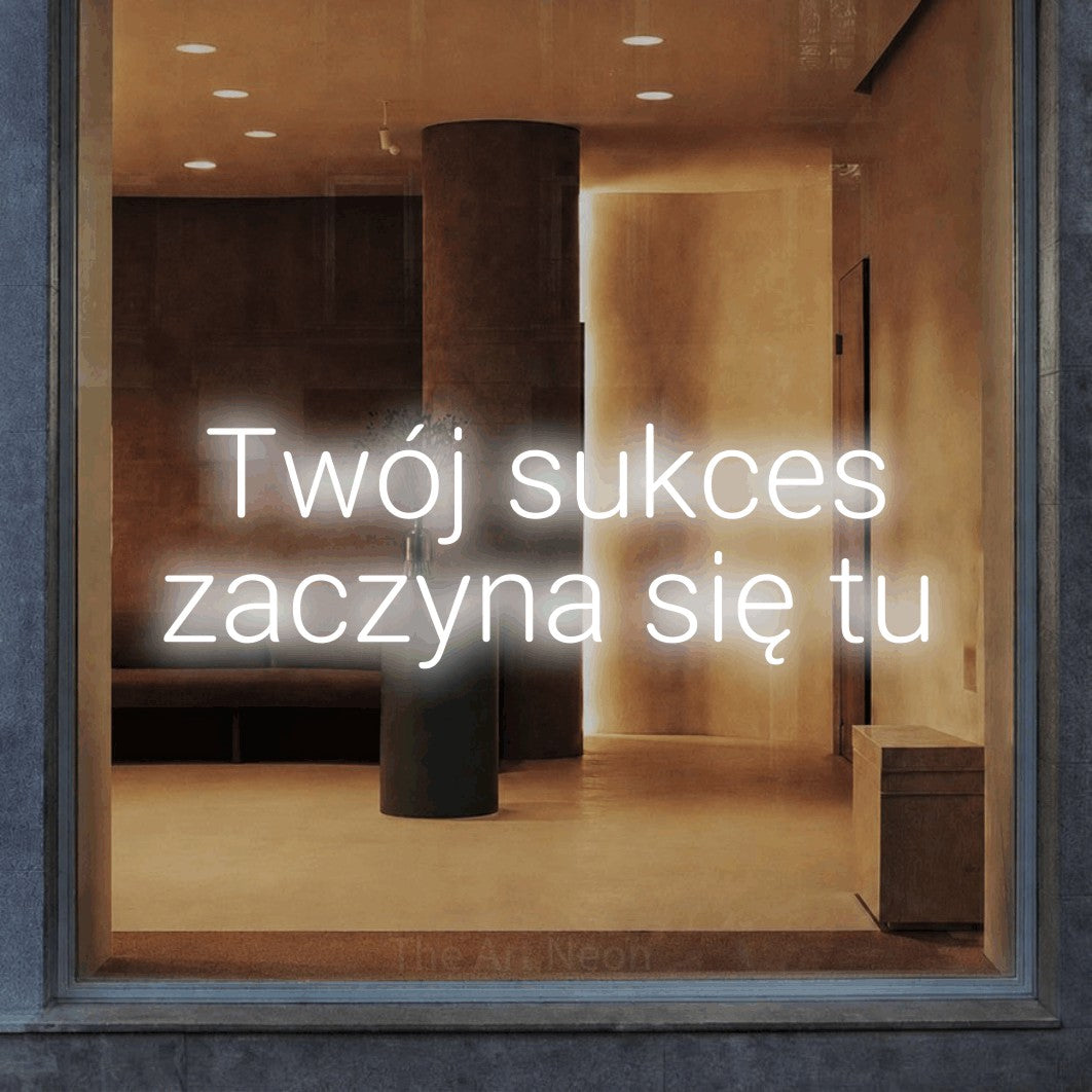 LED neon sign reading “Twój sukces zaczyna się tu”, arranged in two lines.