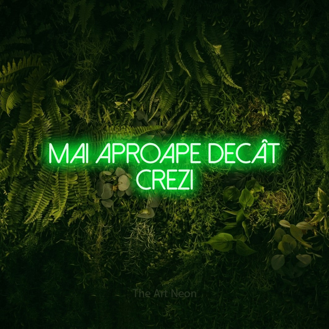 LED neon sign reading “Mai APROAPE Decât Crezi”, arranged in two lines.