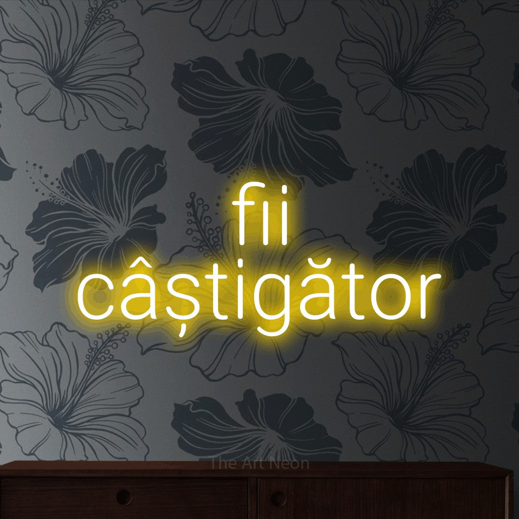 LED neon sign reading “fii câștigător”, arranged in two lines.