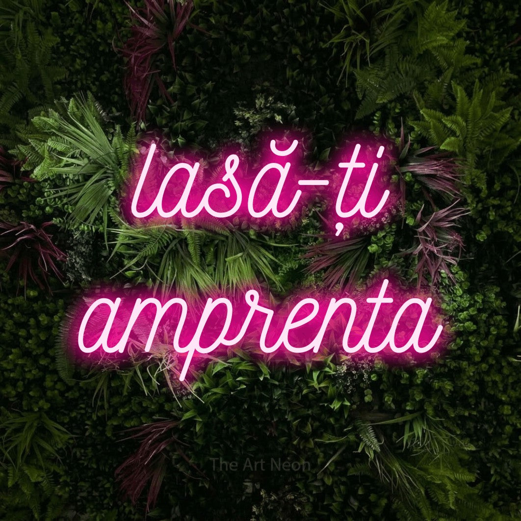 LED neon sign reading “lasă-ți amprenta”, arranged in two lines.