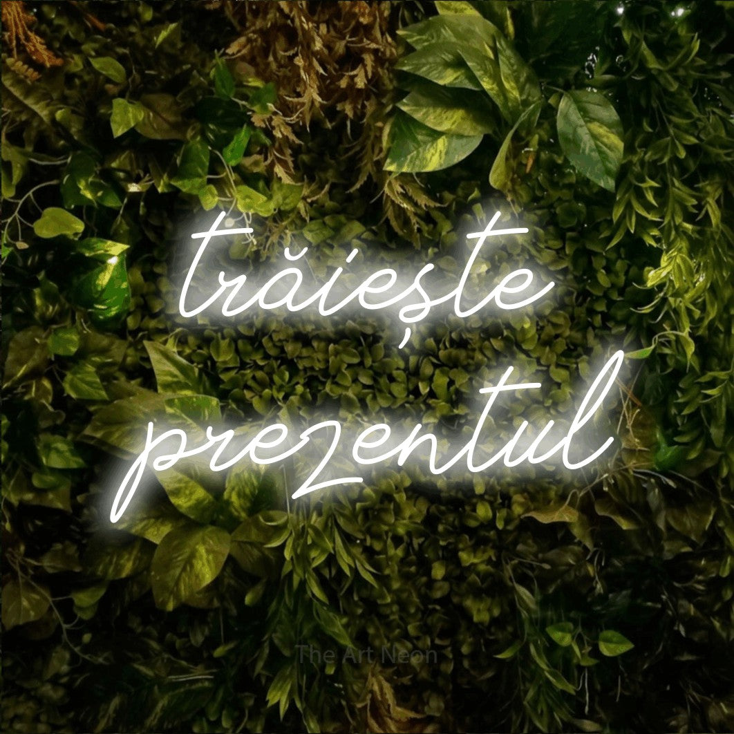 LED neon sign reading “trăiește prezentul”, arranged in two lines.