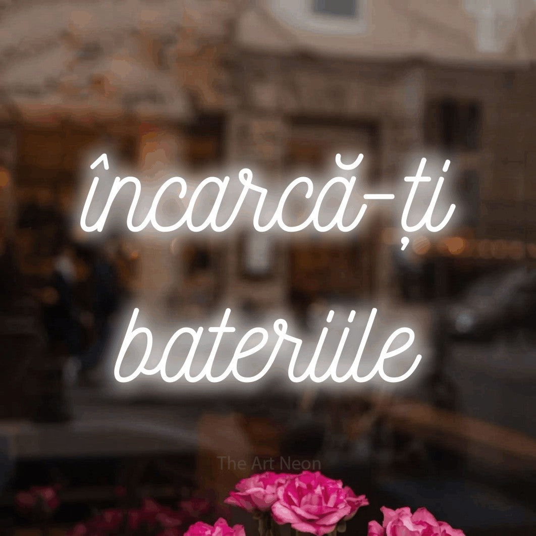 LED neon sign reading “încarcă-ți bateriile”, arranged in two lines.