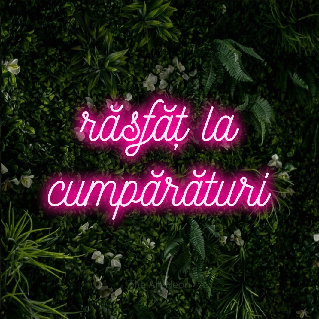 LED neon sign reading “răsfăț la cumpărături”, arranged in two lines.