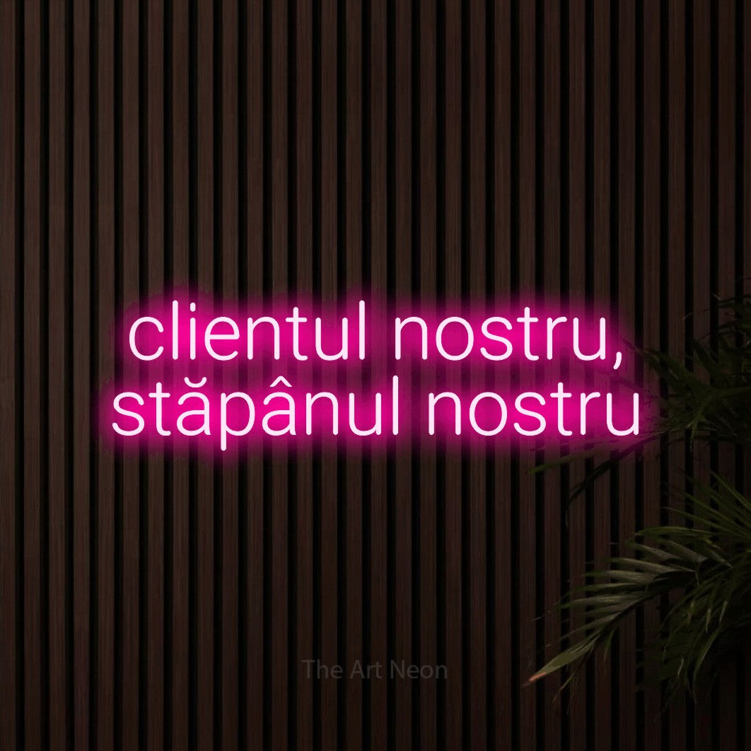 LED neon sign reading “clientul nostru, stăpânul nostru”, arranged in two lines.