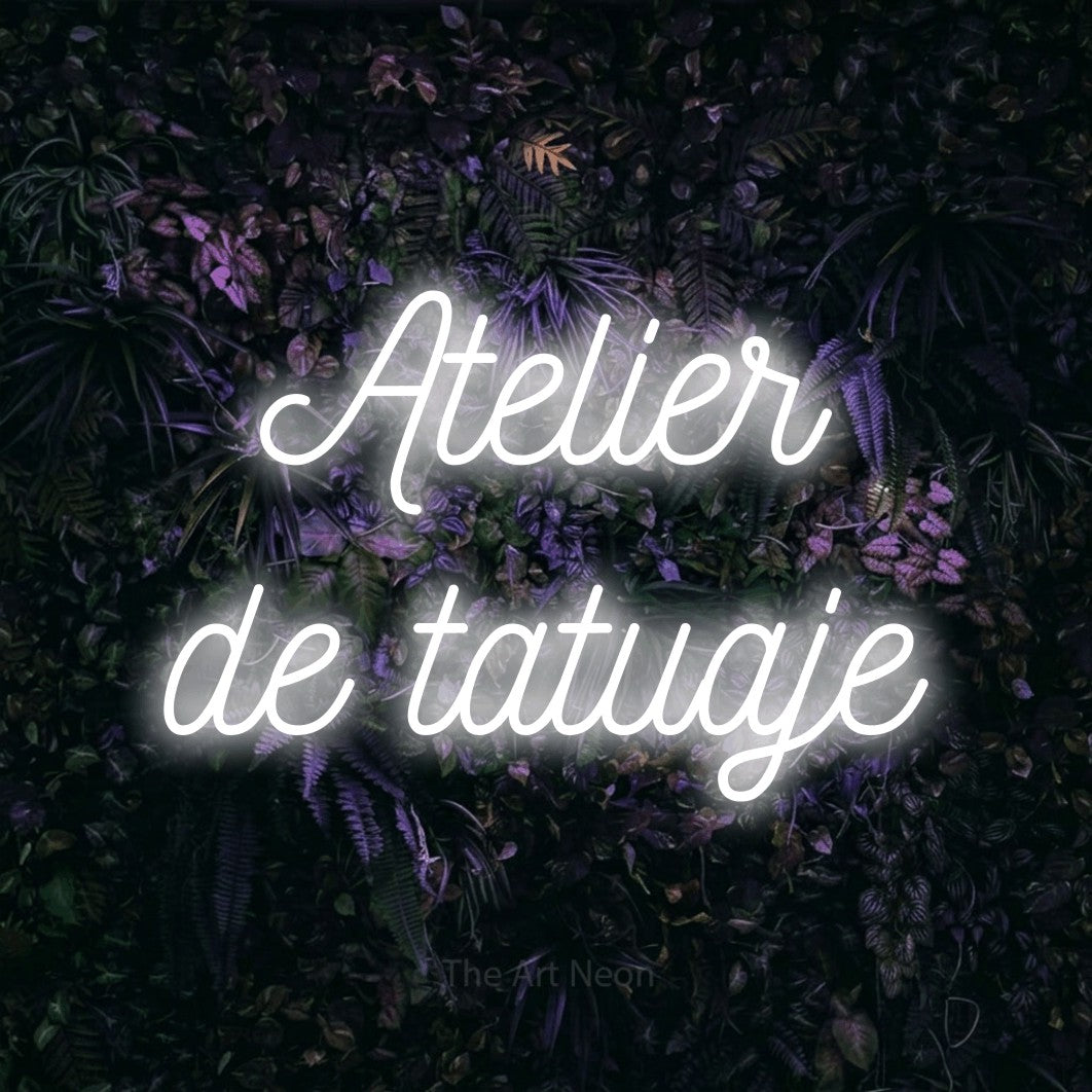 LED neon sign reading “Atelier de tatuaje”, arranged in two lines.