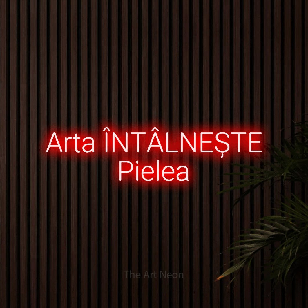 LED neon sign reading “Arta ÎNTÂLNEȘTE Pielea”, arranged in two lines.