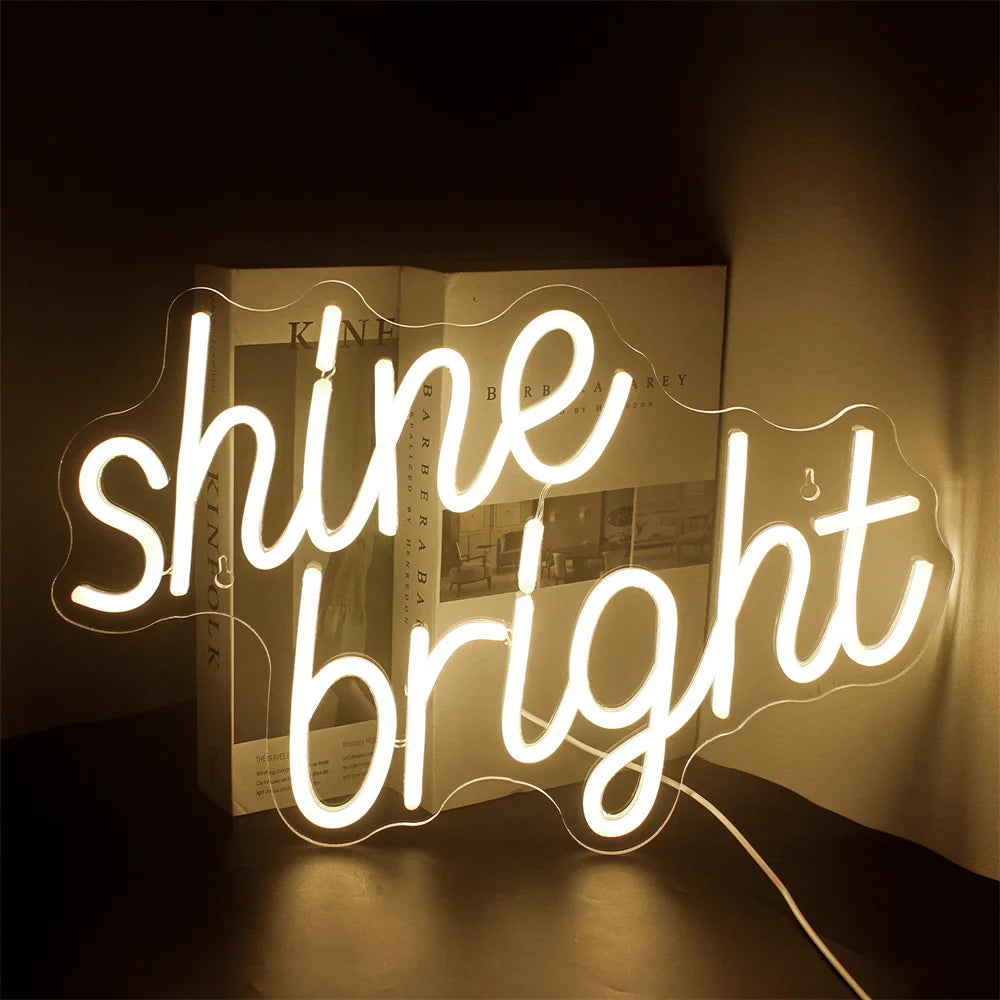 A vibrant LED neon sign displaying the words "Shine Bright" in a lively script font.