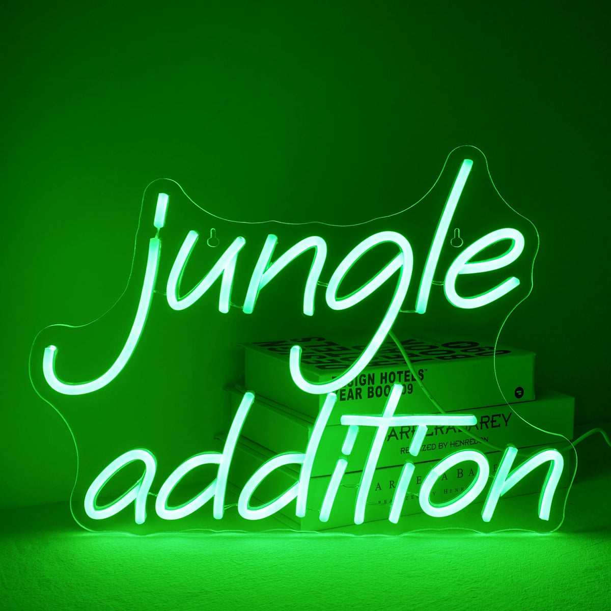 Et levende grønt "Jungle Addition" LED neonskilt, sat mod en minimalistisk hvid vægbaggrund.