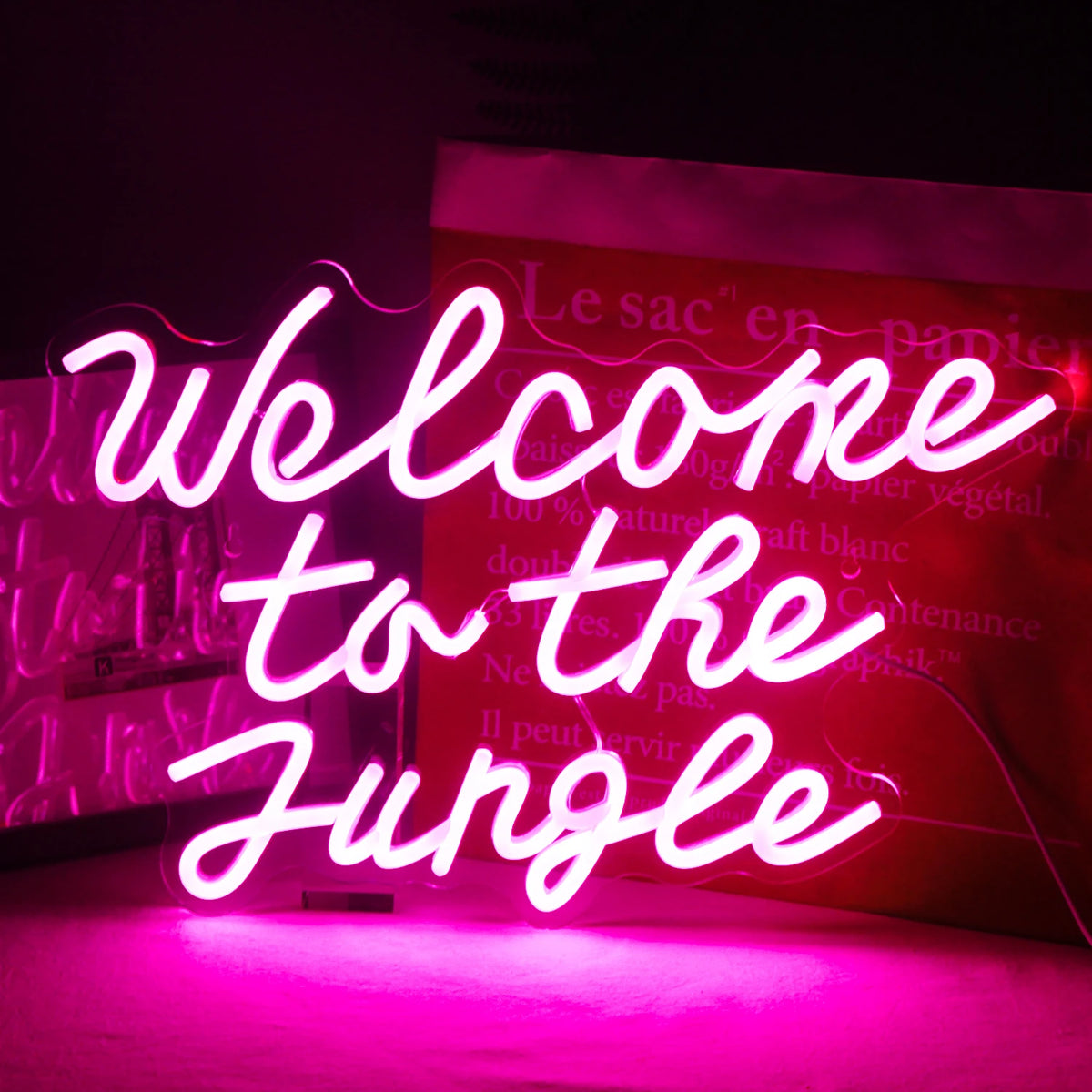 Et levende LED-neonskilt med ordene "Welcome to the Jungle" i et fedt, legende manuskript.