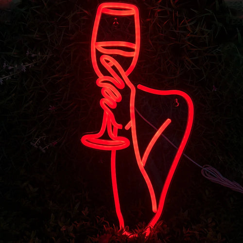 Na zdjęciu widoczny jest jaskrawy neon LED przedstawiający sylwetkę kobiety trzymającej kieliszek wina.