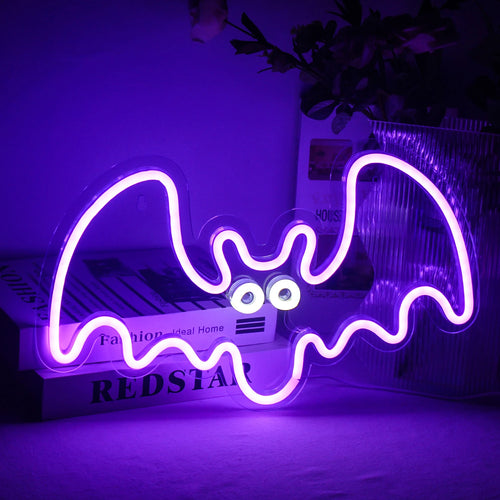 The image depicts a vibrant handmade LED neon sign shaped like a bat.