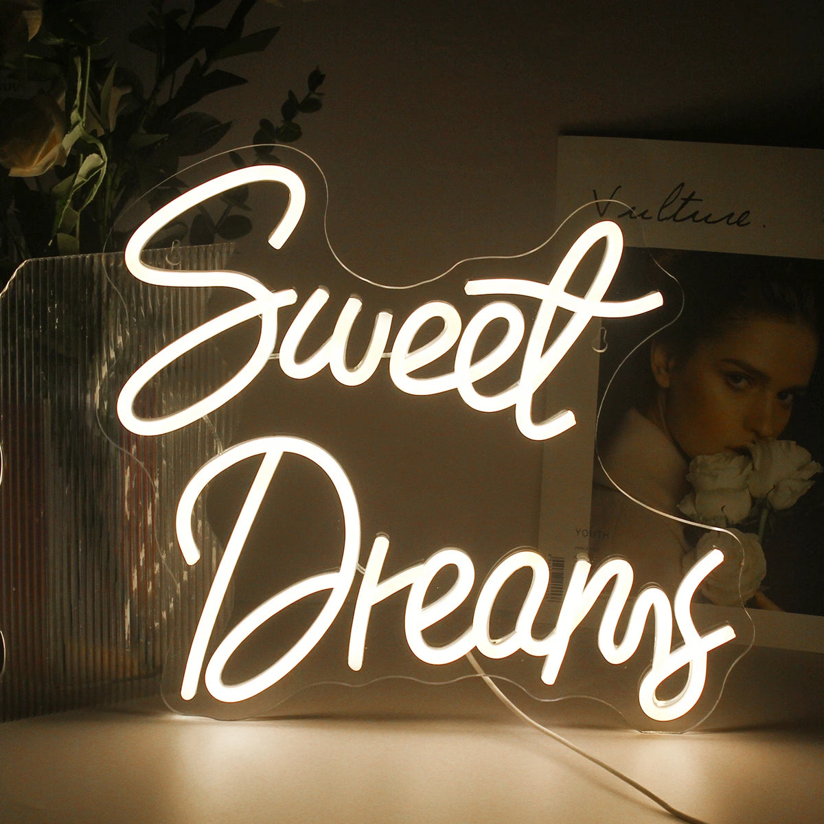 Billedet viser et stilfuldt og levende LED-neonskilt, der viser ordene "Sweet Dreams" i en flydende, kursiv skrifttype.