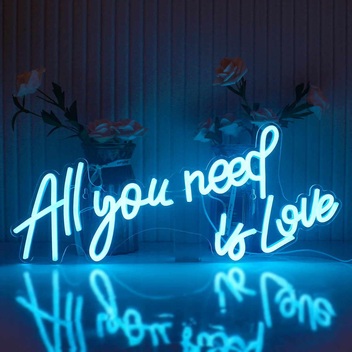 Das Bild zeigt ein leuchtendes LED-Neonschild mit dem Satz „All You Need Is Love“ in einer stilvollen Schreibschrift.