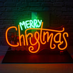 Un letrero de neón LED brillante que dice "Feliz Navidad", con letras cursivas en negrita en color rojo brillante.