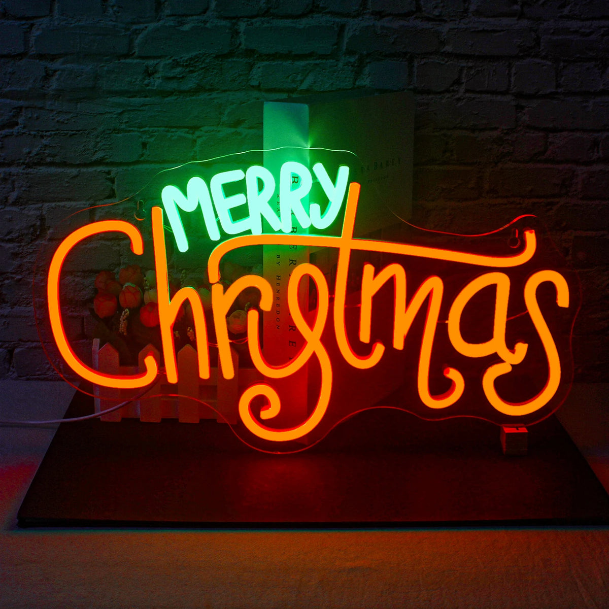 Un letrero de neón LED brillante que dice "Feliz Navidad", con letras cursivas en negrita en color rojo brillante.