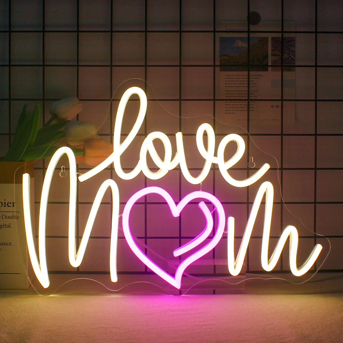 Obrázek zobrazuje zářivý LED neonový nápis s frází „Love Mom“ psanou kurzívou.