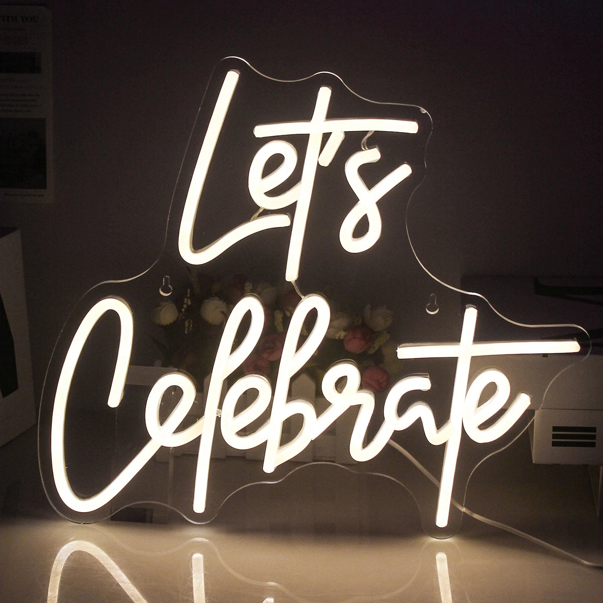 Billedet har et levende "Let's Celebrate" LED neonskilt.