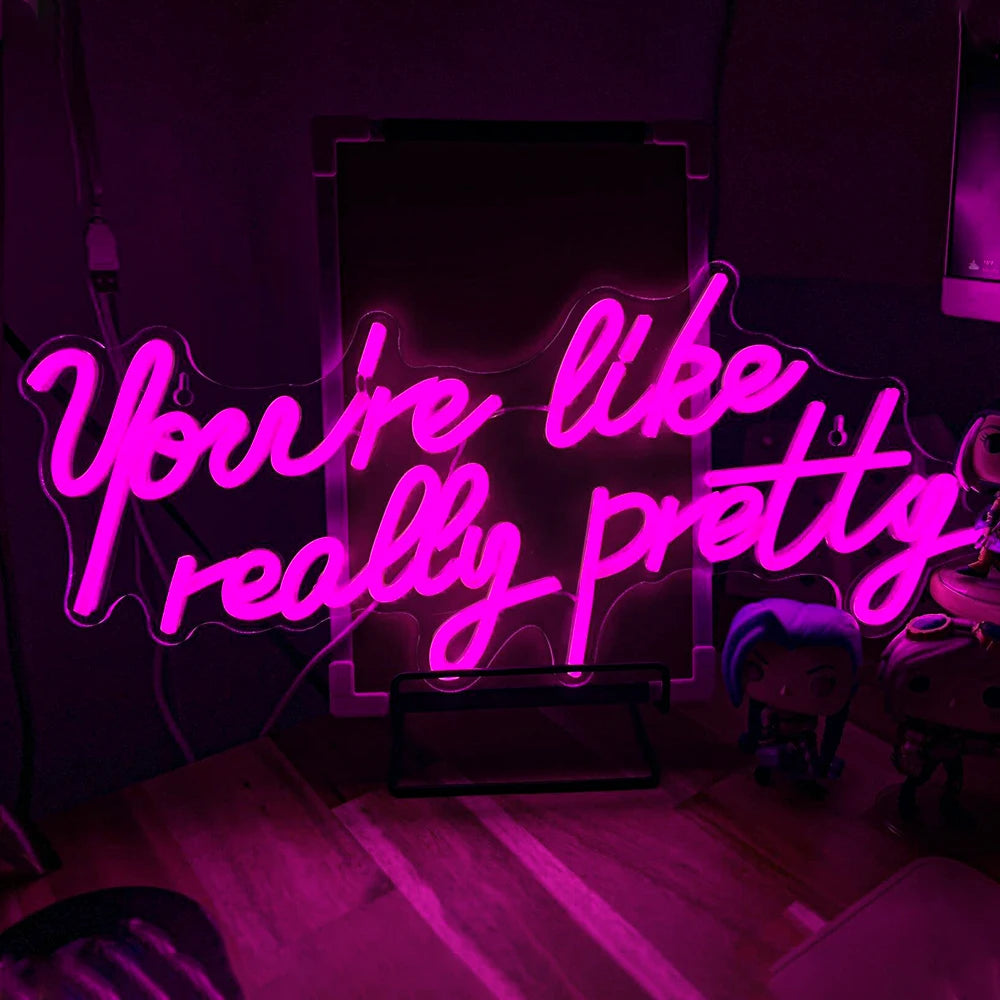 "Et specialfremstillet LED-neonskilt, der viser sætningen 'You're Like Really Pretty' i stilfuld, kursiv håndskrift.