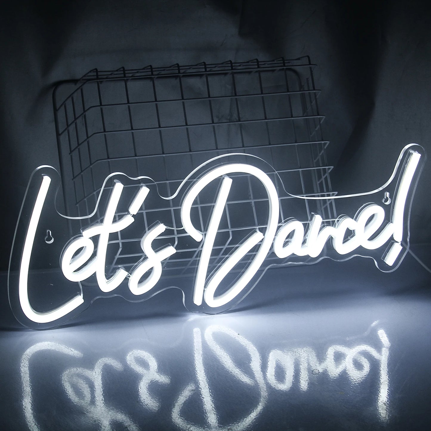 A brightly lit "Let's Dance" LED neon sign in vibrant pink and blue colors.