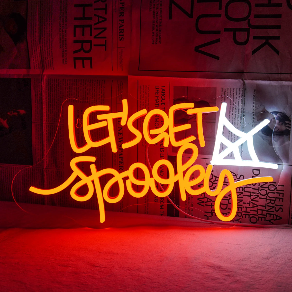 Das Bild zeigt ein leuchtendes LED-Neonschild mit den Worten „Let’s Get Spooky“ in einer verspielten, geschwungenen Schriftart.